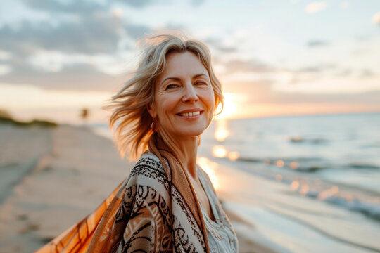 beautiful happy mature woman at the beach on summer day early in the morning