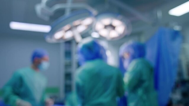 Medical team working in surgical room. Blurred image of doctors cooperating at operational table.