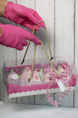 A woman holds a box with a zephyr. Homemade zephyr. Zephyr flowers. Gift box with pink tulips....