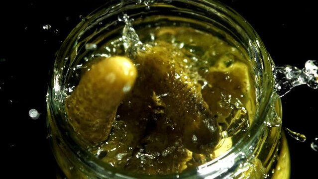 Pickled cucumbers fall into a jar of brine. Filmed on a high-speed camera at 1000 fps. High quality FullHD footage