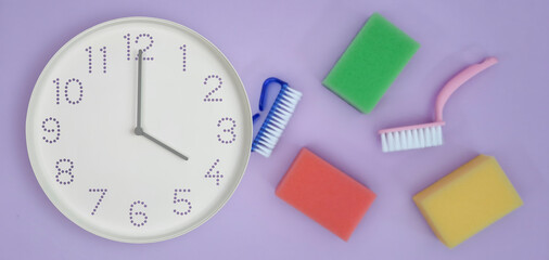 4 o'clock, Daytime. Banner. Cleaning time. White wall clock on background of kitchen sponges and...
