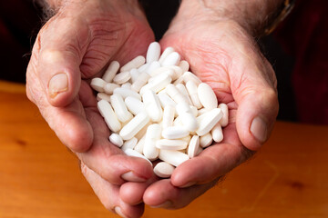 Senior adult is holding many pills in her hands