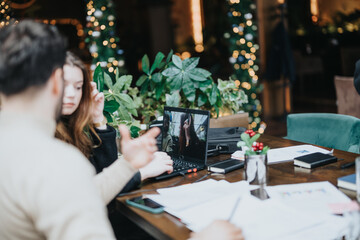 Christmas business meeting with remote team member on laptop screen.