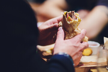 close-up of man eating doner kebab hand.