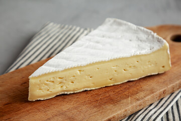 Organic Brie Cheese on a wooden board, low angle view. Close-up.
