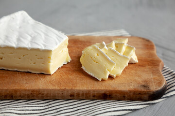 Organic Brie Cheese on a wooden board, low angle view.