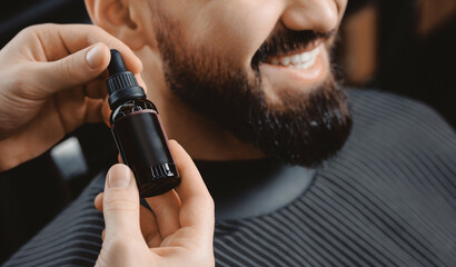 Oil for beard in dropper, process of moisturizing skin, cosmetic for growth hair of man