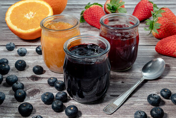 Homemade blueberries marmalade, assortment of homemade jams in glass jars. Front view, seasonal...