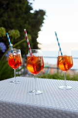 Three aperol spritz on a summer evening in a mediterranean pub - 737528083
