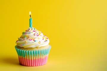 Delicious cupcake with a candle on a yellow backdrop