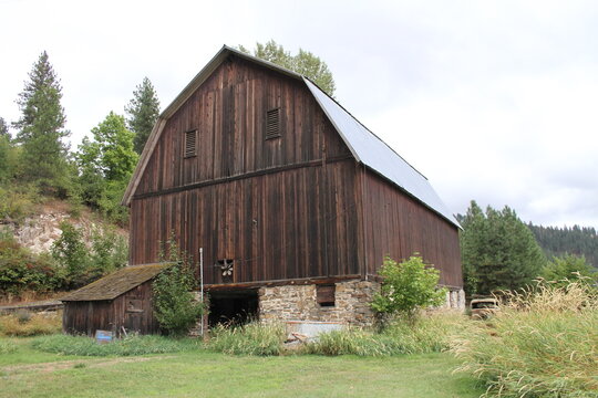 old wooden hay barn with metal roof and stone foundation in very good condition