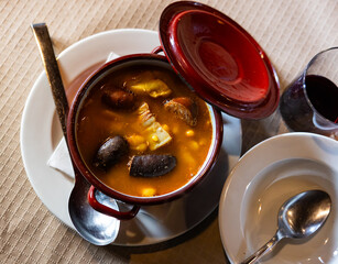 Asturian fabada soup with white beans and blood sausage served in bowl