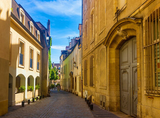 Fototapeta na wymiar View of typical narrow streets in old historic center of French city of Dijon in summer day.
