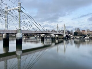 Albert Bridge in Chelsea London.  During the day with long exposure, water is smooth.  No people