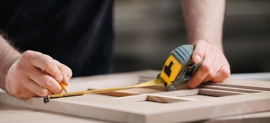 Banner DIY carpentry workshop industry. Closeup of craftsman hand making wooden facade of handmade...