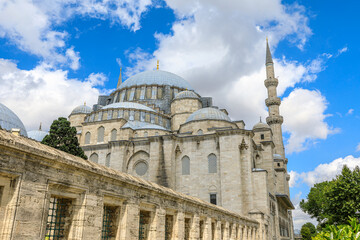 Fototapeta na wymiar Suleymaniye Mosque in Istanbul, Turkey. Blue cloudy sky creates a contrast with the stone structure of the mosque. Commissioned by Sultan Suleyman the Magnificent in 16th century.