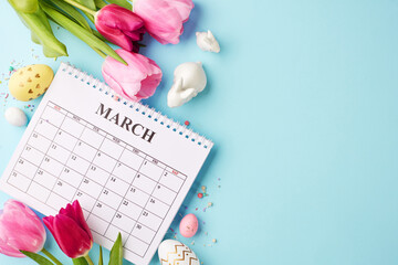 March musings: Easter's arrival. Top view of calendar page, vibrant pink tulips, white porcelain bunnies, Easter eggs, confetti on a pastel blue surface  for springtime planning