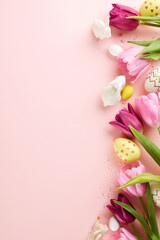 Spring's soft bloom. Top view vertical composition of pink and purple tulips, white porcelain bunnies, and decorated eggs, arrayed on a pastel pink surface with space for advert or greetings