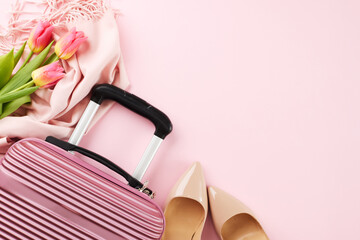 Spring getaway: a journey in pastel hues. Top view of stylish pink suitcase, beige high heels, cozy pink scarf, fresh bouquet of pink tulips on soft pink background with space for travel promotions