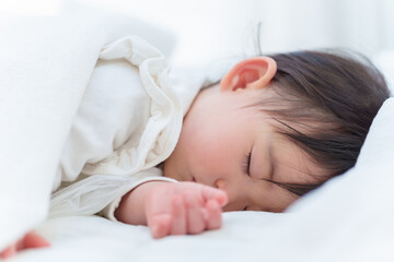Obraz na płótnie Canvas ベッドでお昼寝する赤ちゃん