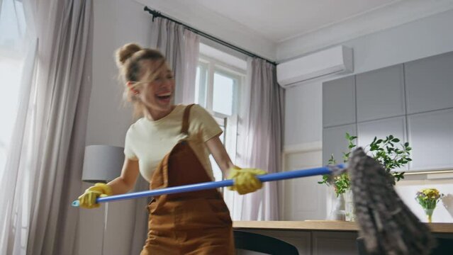 Comic lovers cleaning apartment closeup. Woman holding mop fighting with husband