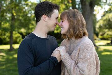 A lovely engagement portrait of a couple with beautiful background of trees.