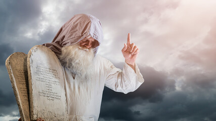 The Old Testament biblical prophet Moses holds the tablets with the ten  commandments - obrazy, fototapety, plakaty