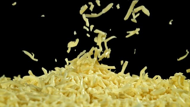 Shredded cheese falling on black background. Filmed on a high-speed camera at 1000 fps. High quality FullHD footage