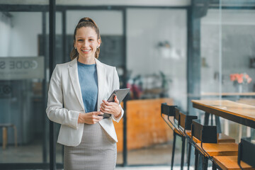 Business woman concept, Smiling professional businesswoman holding a tablet in a contemporary office setting, exuding confidence and efficiency.