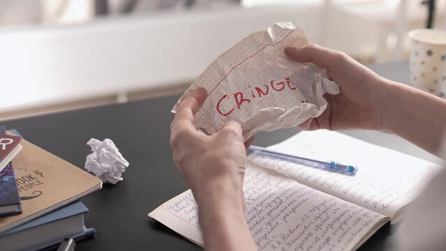 Schoolboy unwraps a piece of paper with cringe