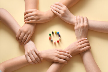 People with pawns holding hands on beige background. Inclusion concept