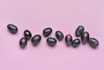 Sweet black grapes on lilac background