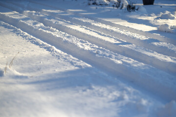 Fototapeta na wymiar Closeup of car tire tracks through fresh deep snow after Midwest snowstorm