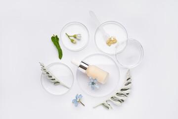 Petri dishes with sample, herbs and bottle of cosmetic product on white background