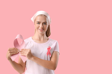 Young woman with ribbons on pink background. Breast cancer awareness concept