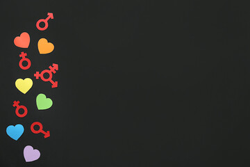 Paper hearts with gender symbols on dark background. LGBTQ concept