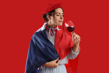 Young woman with flag of France and wine on red background