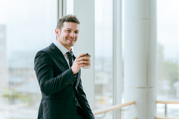 ビルの中でコーヒーを飲む外国人ビジネスマン（白人男性）
