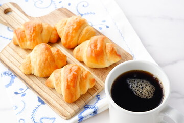 焼き立てでサクサクの食感のクロワッサンと、淹れたてのコーヒーの朝食

