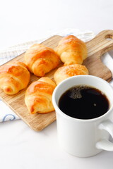 焼き立てでサクサクの食感のクロワッサンと、淹れたてのコーヒーの朝食
