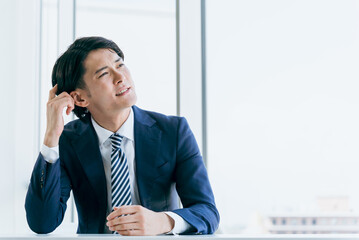 オフィスで悩むアジア人ビジネスマン（転職・起業・悩み・困る）
