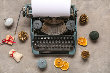 Vintage typewriter with Christmas decor on grey grunge background