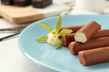 Glazed vanilla curd cheese bars served on white wooden table, closeup