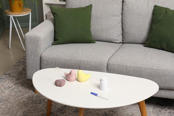 Pregnancy test with pill bottle and decor on table in living room