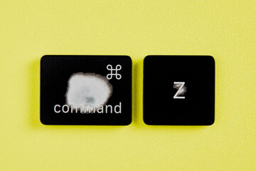 The command key and Z key are worn out due to frequent use and are removed from a keyboard with yellow background
