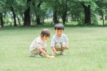 Naklejka na ściany i meble 森・公園でシャボン玉で遊ぶ兄妹・子供（ピクニック・キャンプ・アウトドア） 