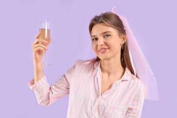 Happy bride in pajamas with glass of champagne on lilac background. Hen Party