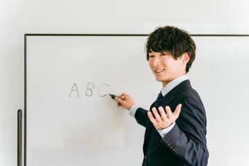 ホワイトボードに記入する男性（塾講師・教師・予備校）
