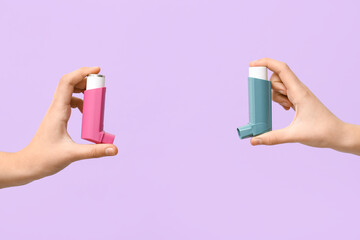 Child's hands with asthma inhalers on lilac background - obrazy, fototapety, plakaty