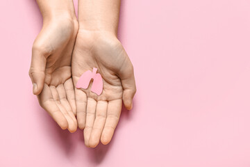 Female hands with paper lungs on pink background
